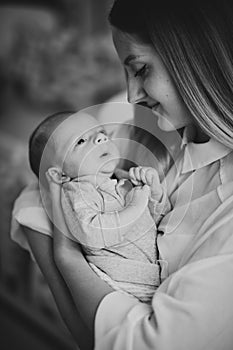 Newborn baby on his mother`s hands. Black and white photo