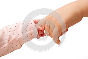 Newborn baby holding finger of older kid.