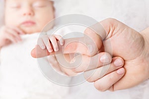 Newborn Baby Holding Mother Hand, Mom Finger and New Born Kid on White