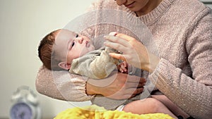 Newborn baby holding mothers finger lying in mothers arms, loving relation