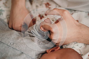 Newborn baby holds dad& x27;s hand. Close up of hands of child and parents