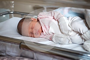 Newborn baby in the hospital. The baby has just been born. Sleepy baby lies in the crib photo