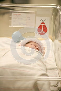 Newborn baby in a hospital blanket asleep