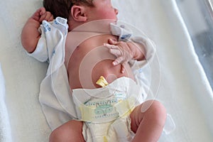 Newborn baby in a hospital crib with a baby blanket