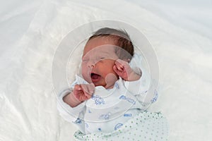 Newborn baby in a hospital crib with a baby blanket