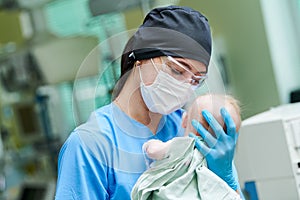 Newborn baby in hospital at neonatal resuscitation center with nurse