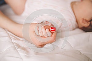 Newborn baby infant holding mother hand palm with fingers