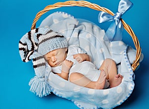 Newborn Baby Inside Basket, New Born Kid Dream in Woolen Hat photo