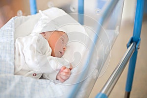 Newborn baby laying in crib in prenatal hospital