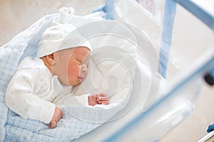 Newborn baby laying in crib in prenatal hospital