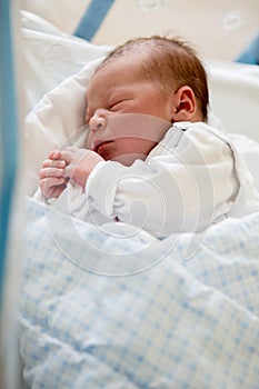 Newborn baby laying in crib in prenatal hospital