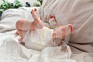 Newborn baby laying on a sofa with disposable diapers ready to change