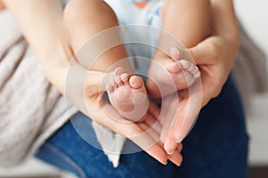 Newborn baby legs in mother hands, close-up