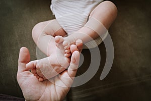 Newborn baby legs. Mother touching baby feet. Maternity concept.