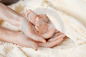 Newborn baby legs  in motherâ€™s nd father`s palm. Happy parents  holding theyr baby feet close up.  Maternity, family, birth