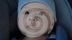 A newborn baby lies in a stroller. Close-up of a child's face.