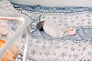 newborn baby lying alone on bed in hospital