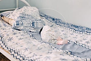 newborn baby lying alone on bed in hospital