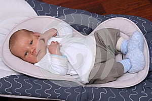 Newborn baby lying in bouncer chair photo