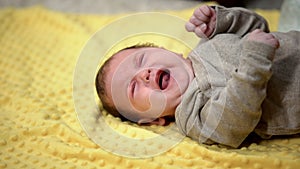 Newborn baby lying and crying suffering abdominal colic, emergence of tooth photo