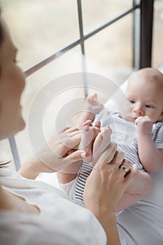 Newborn baby lying on his mother`s lap