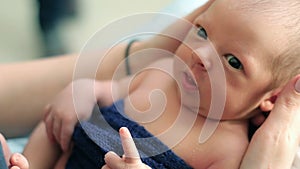 Newborn baby lying on his mother`s lap