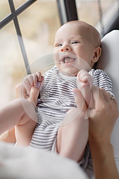 Newborn baby lying on his mother`s lap