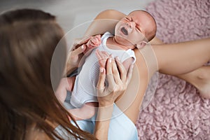 Newborn baby lying on his mother`s lap