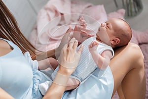 Newborn baby lying on his mother`s lap