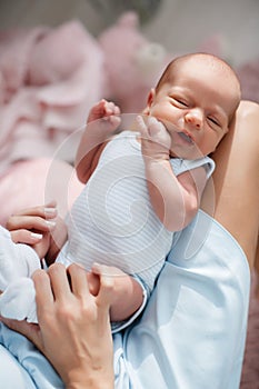 Newborn baby lying on his mother`s lap