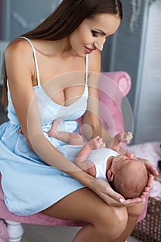 Newborn baby lying on his mother`s lap