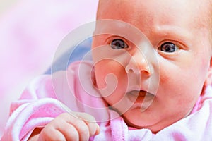 Newborn baby lying in pyjamas and towel