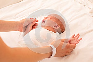 Newborn baby and mom are holding hands