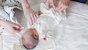 Newborn baby, mother and nurse - swaddling the infant