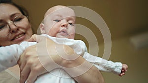 Newborn baby in mothers a arms. Happy family kid dream concept. Mother and son baby close-up portrait indoors. Cute