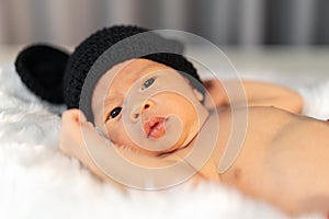 Newborn baby in mouse costume on fur bed