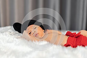 Newborn baby in mouse costume on fur bed