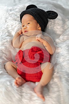 Newborn baby in mouse costume on fur bed