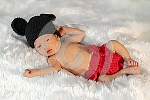 Newborn baby in mouse costume on fur bed