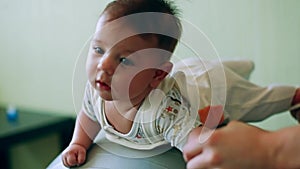 Newborn baby play with parents on a gym ball