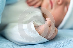 Newborn Baby Red Cute Face Portrait Early Days Sleeping In Medical Glass Bed On Blue Background. Child At Start Minutes