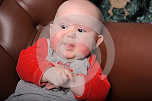 Newborn baby in red and gray jumpsuit