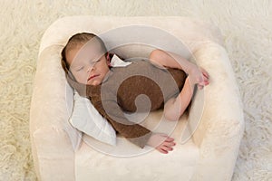 Newborn baby relaxing in armchair