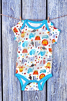 Newborn baby romper hanging on rope.