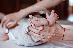 Newborn Baby`s feet on female hands closeup