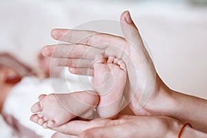 Newborn Baby`s feet on female hands closeup