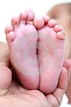 Newborn Baby`s feet.Mother holding newborn baby legs