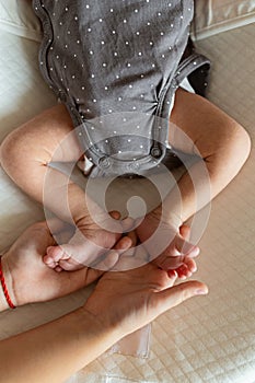 Newborn Baby`s feet. Sister holding newborn baby legs. health care, hygiene, happy family concept