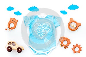 Newborn baby`s sleep concept. To put the child to bed. Baby bodysuit near clouds and cbaby accessories on white