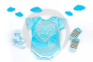 Newborn baby`s sleep concept. To put the child to bed. Baby bodysuit near clouds and cbaby accessories on white